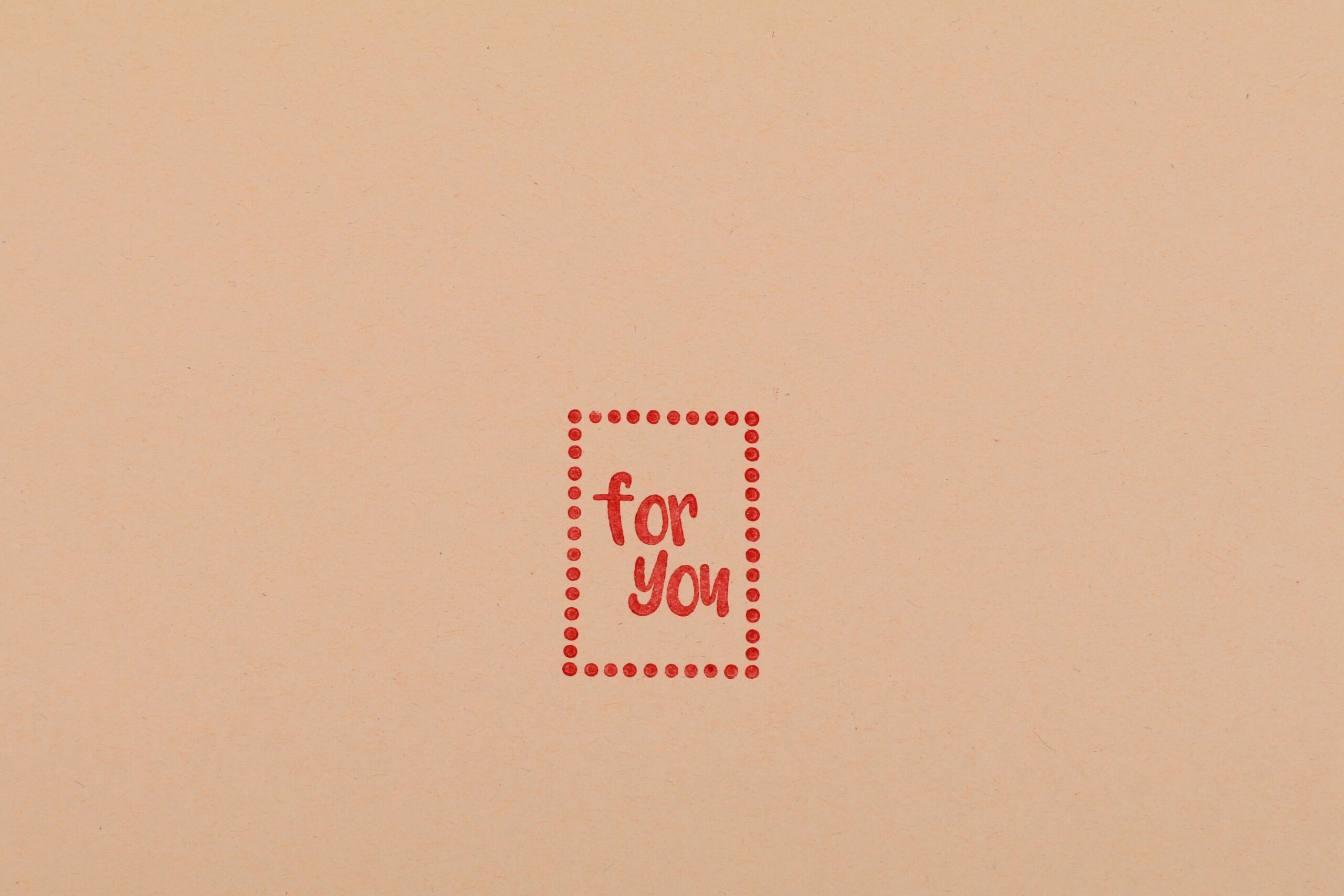 Simple 'For You' text in red on blank pink paper background. Perfect for personalization.